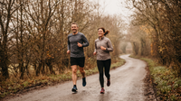Two adults jogging on a quiet road